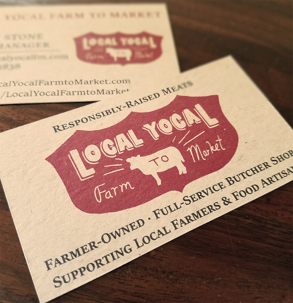 Two business cards for local butcher shop printed on brown kraft paper.